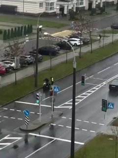 Stranger helps restart stalled motorcycle while traffic police officer pushes it in the rain